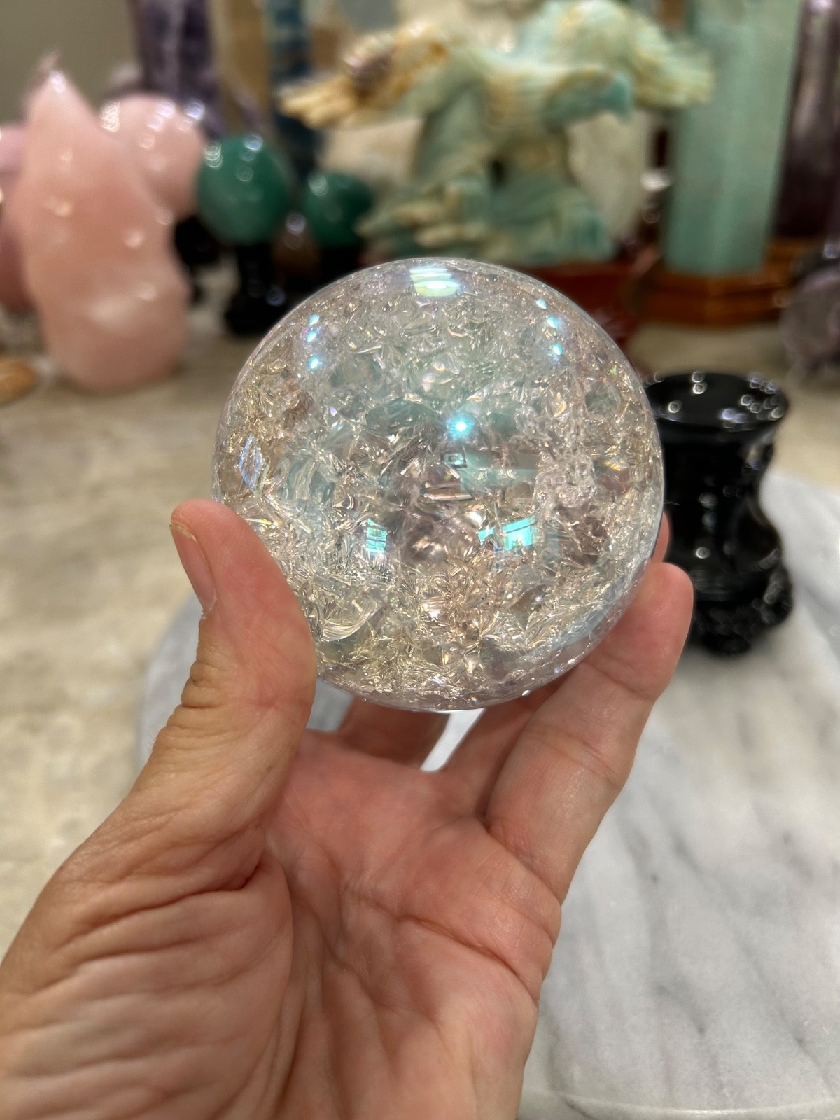 Aura coated quartz crackle sphere with black resin stand