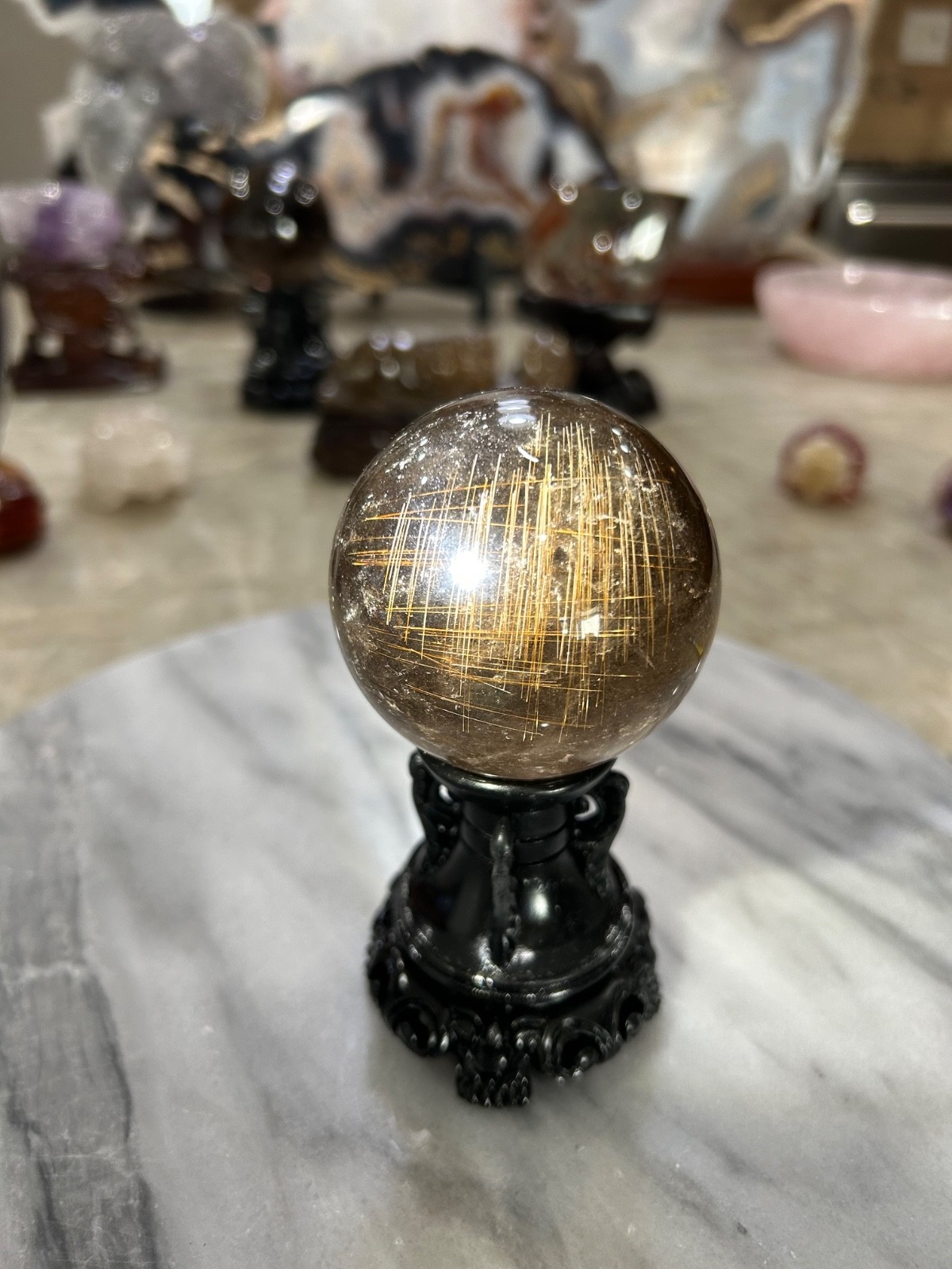 Smoky quartz rutile sphere on resin stand 2.47”