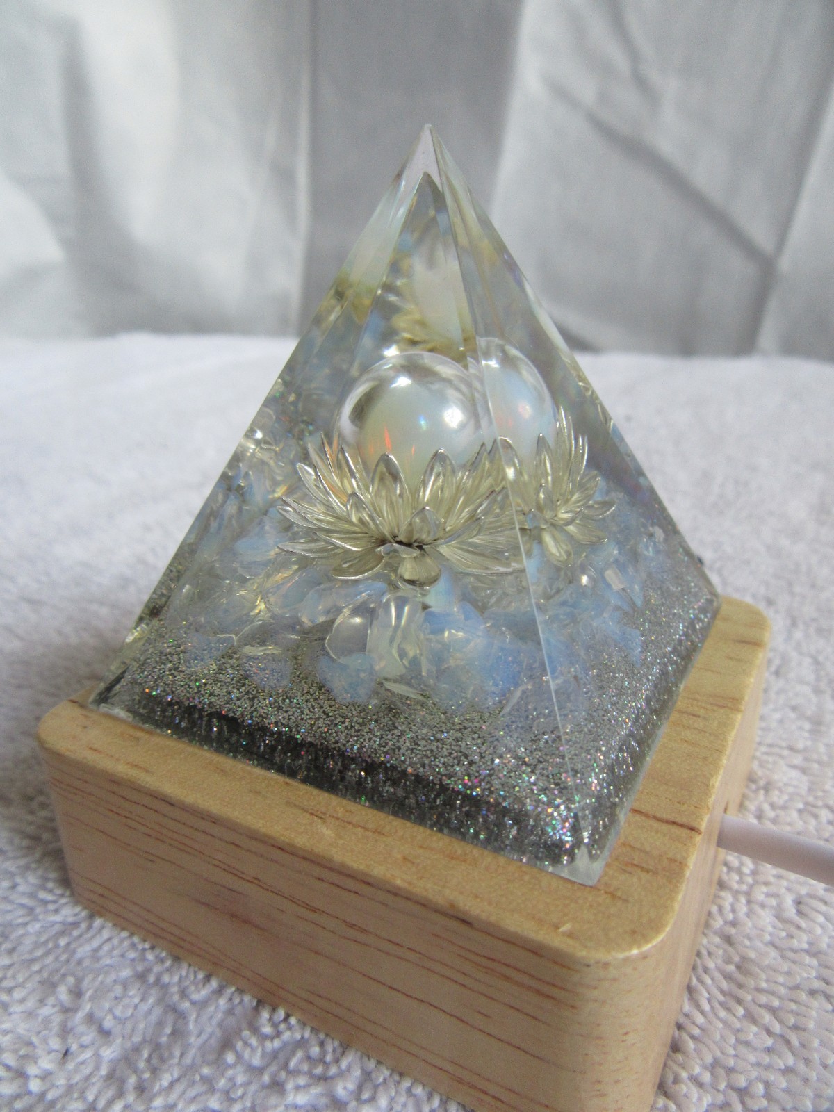 Orgone Pyramid silver-gold Pyramid with white lighted wood base
