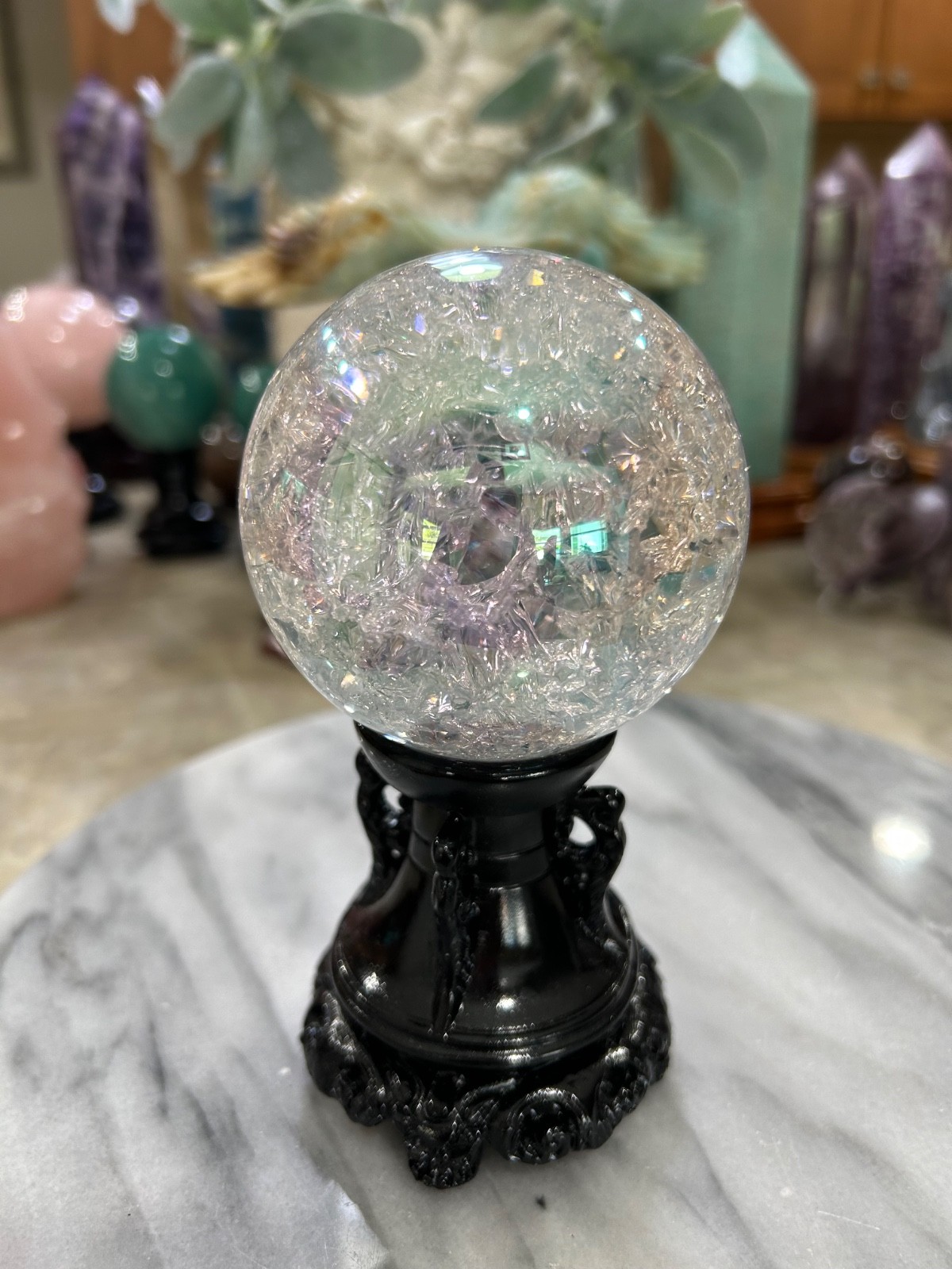 Aura coated quartz crackle sphere with black resin stand